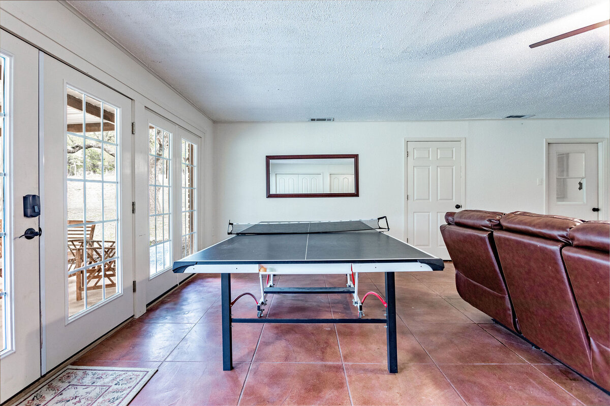 Living room area with comfortable seating and ping pong table - La Roca Ranch