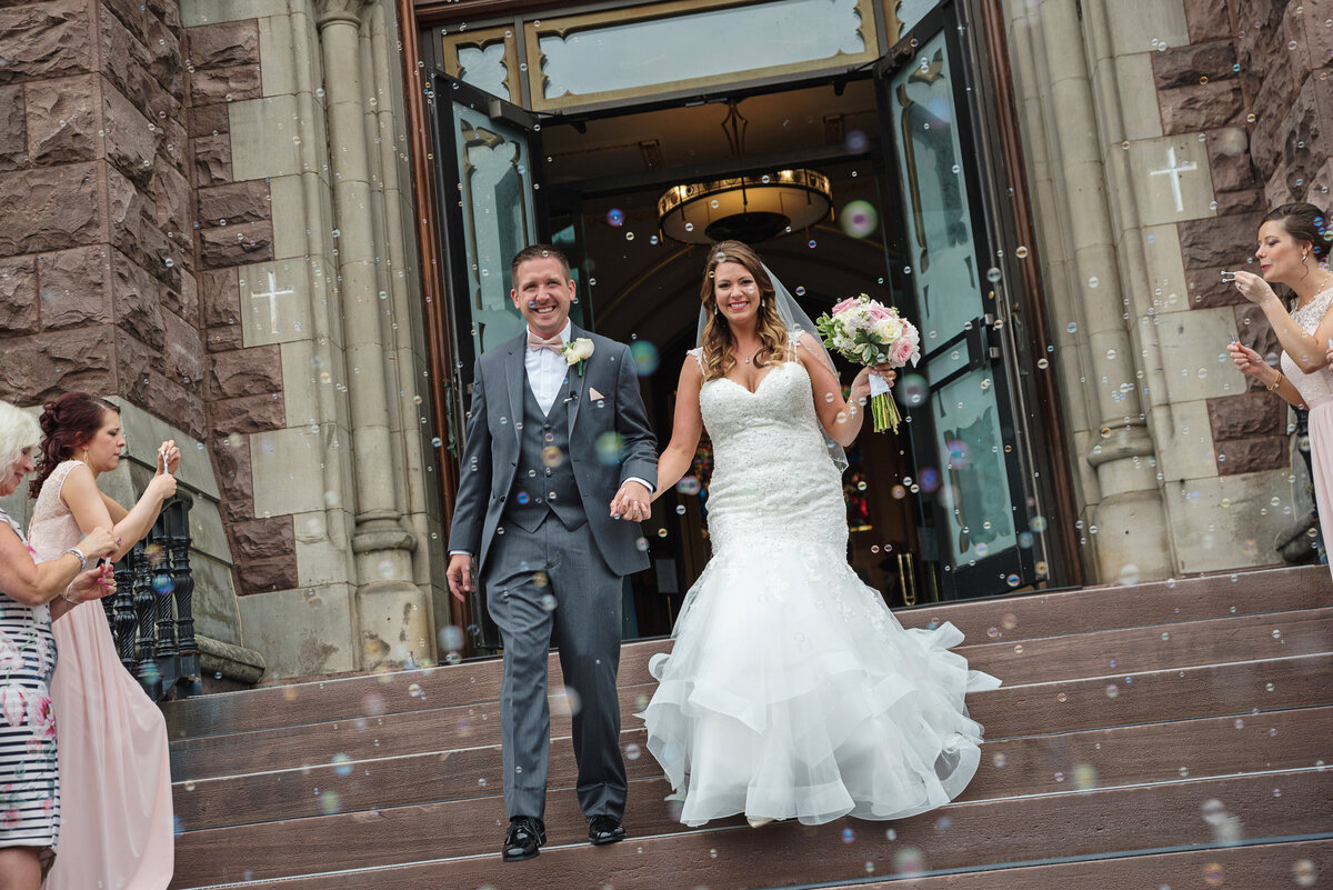 Wedding couple celebrates after ceremony at Saint Peters Cathedral in Erie.