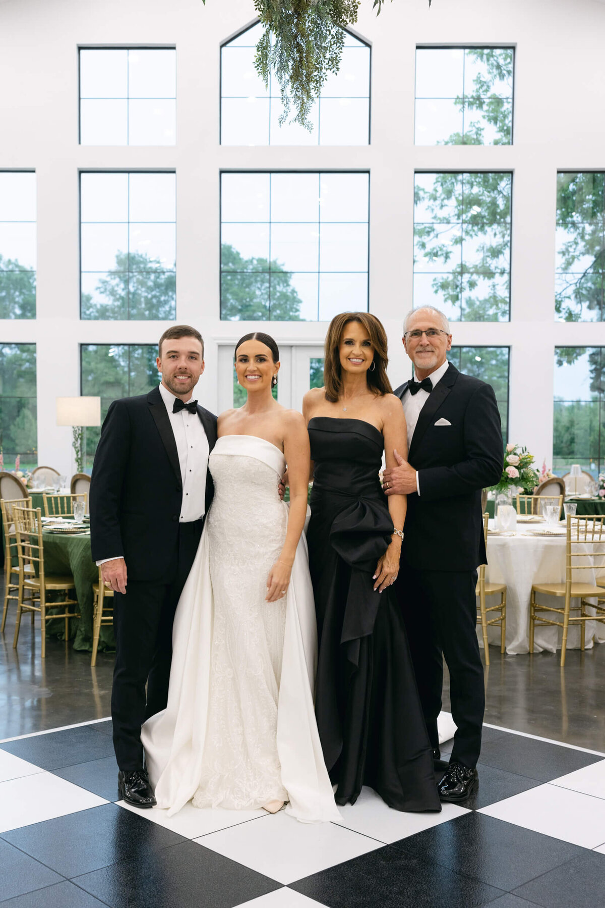 A wedding day photo of the bride and groom with the brides parents