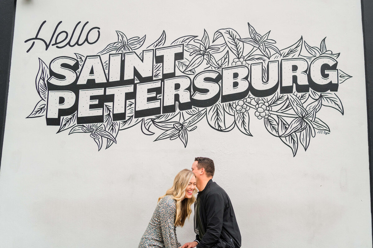 A couple laughing in front of a graffiti wall in St.Petersburg