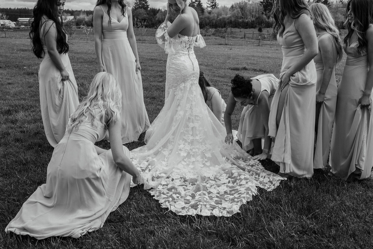 Bridesmaids arranging wedding dress train