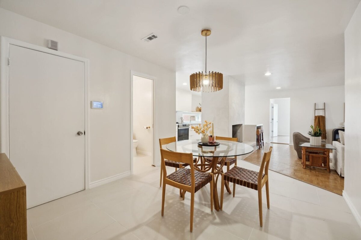 Dining area at 3120 Chapel Downs Dr Dallas TX featuring glass-top table, pendant lighting, and open concept layout connecting to kitchen and living room — Haven Realty Group listing.