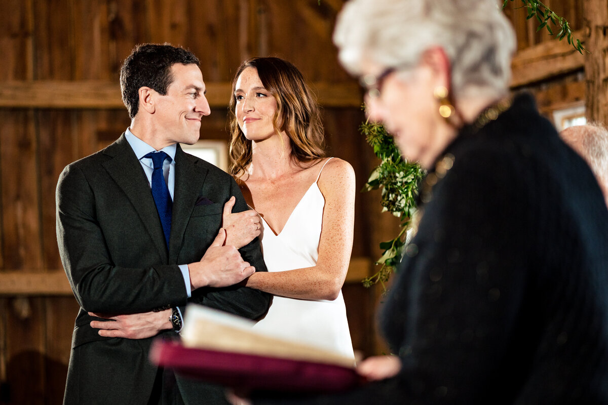 A wedding couple embracing and looking into each others eyes at the brides grandmother reads a blessing during the ceremony in Ann Arbor Michigan