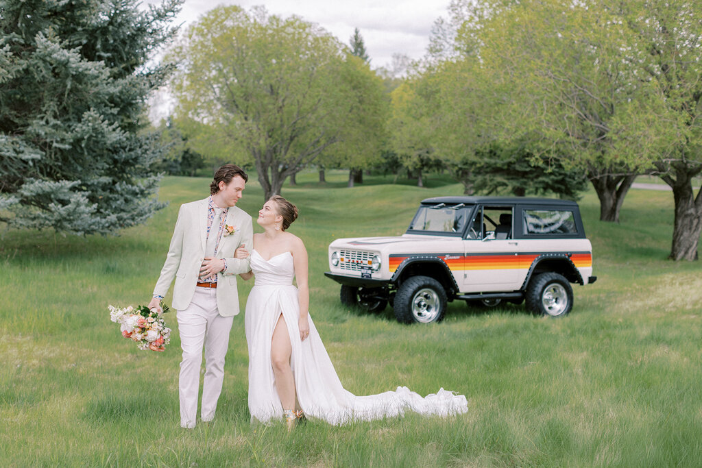 Bride and Groom walking the property of Sugar Pine Island, a romantic wedding venue in Foothills, Alberta, featured on the Brontë Bride Vendor Guide.