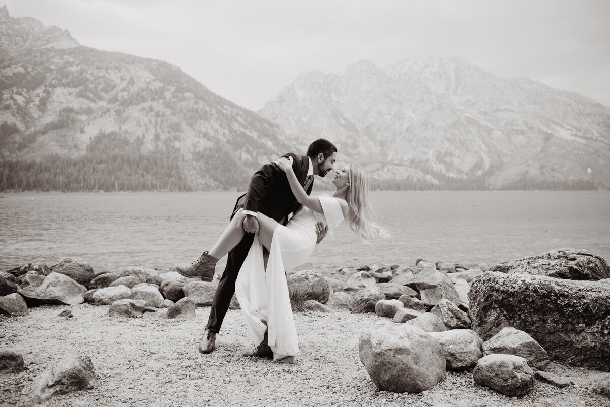 Photographers Jackson Hole capture bride and groom kissing in black and white portrait