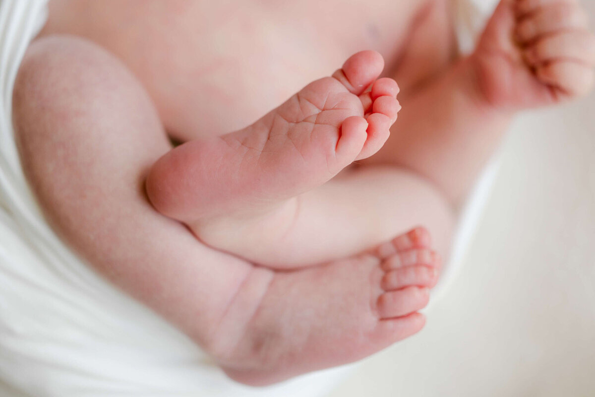 Soft natural light portrait by a newborn photographer Bay Area, baby sleeping on bed.