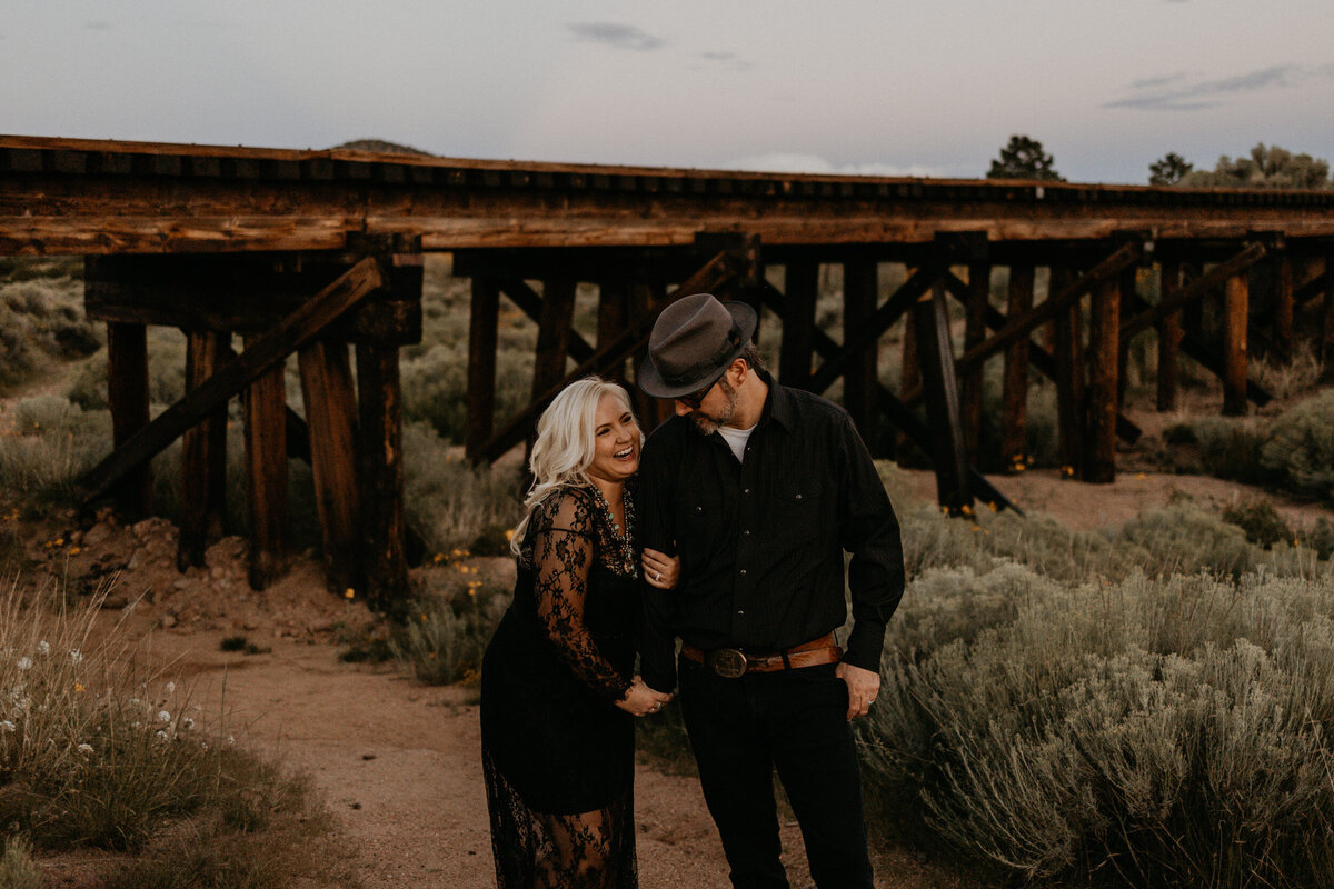 newly weds walking along  a wooden train bridge in Santa Fe