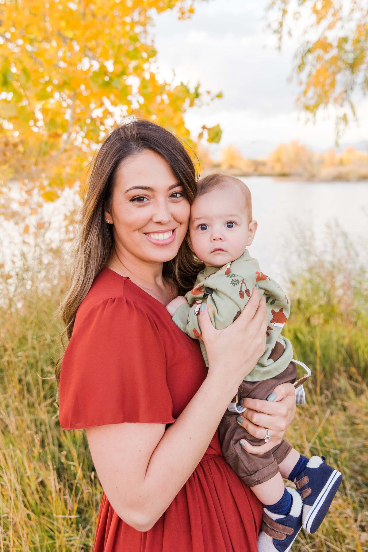 mom in fall dress snuggles her baby in Boulder, CO