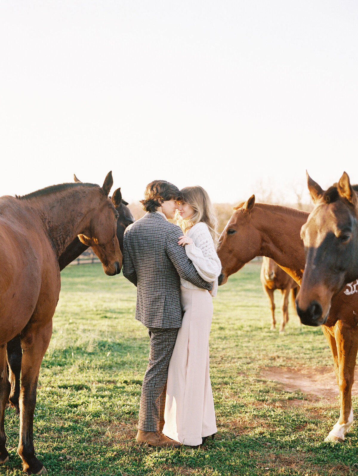 Equestrian Couple holding hands during engagement session with horses
