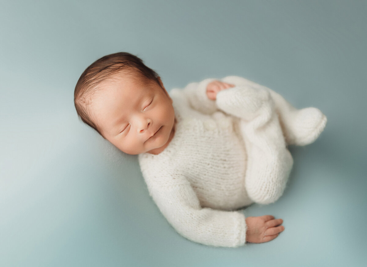 newborn baby boy on aqua blue backdrop