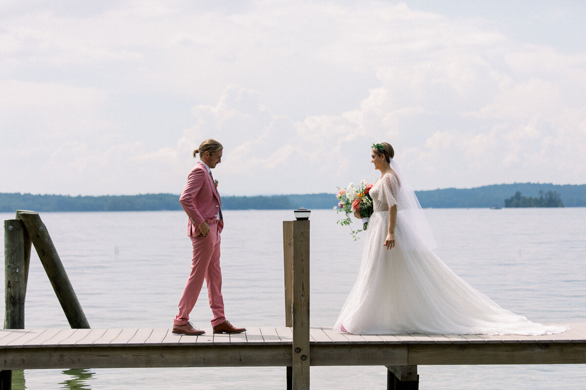bride facing groom at colorful private lakeside wedding in New Hampshire