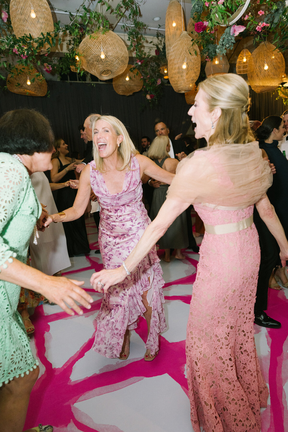 A group of women holding hands on the dance floor. 