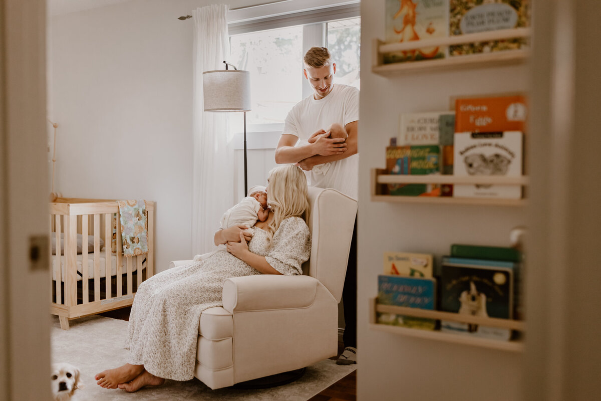 Parents holding twins in baby room