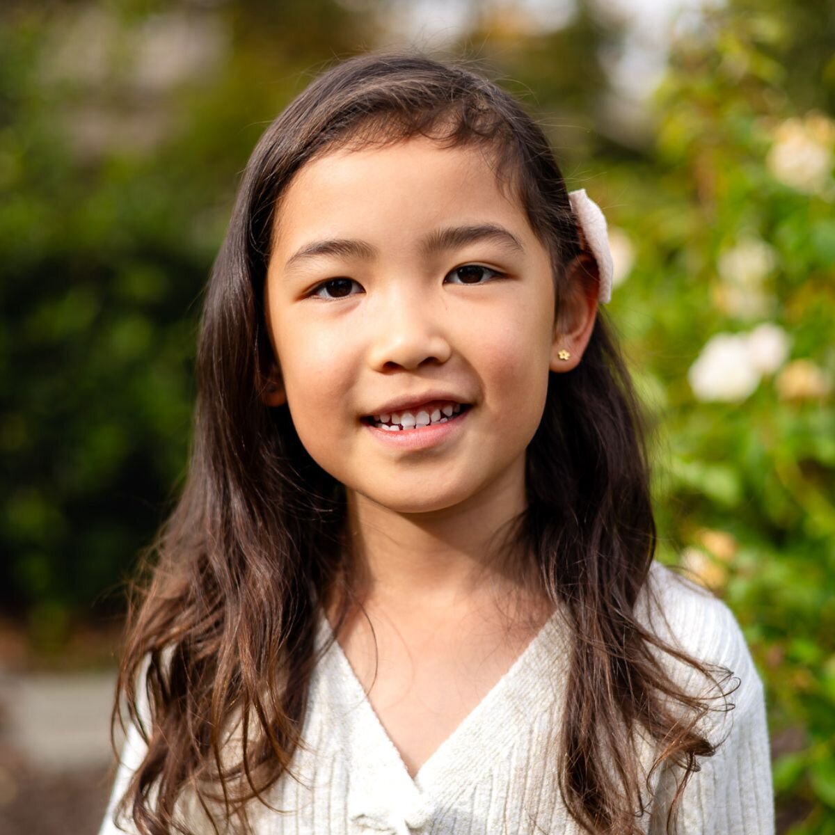 Young girl smiling among roses during Bay Area school photography lifestyle session – Ellobelle Photography