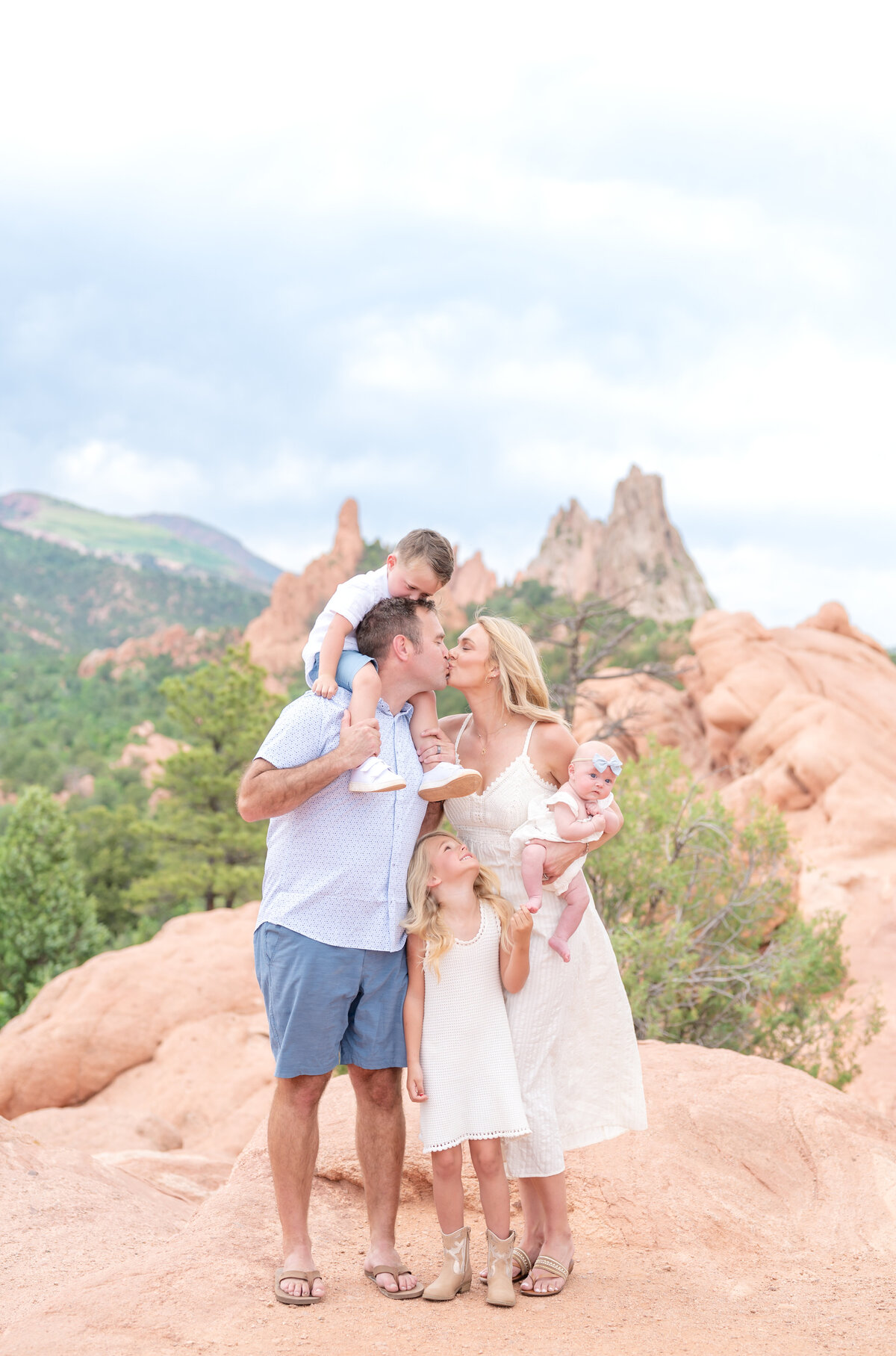 Family of 4 posing for a portrait photo together at Garden of the Gods Park in Colorado Springs