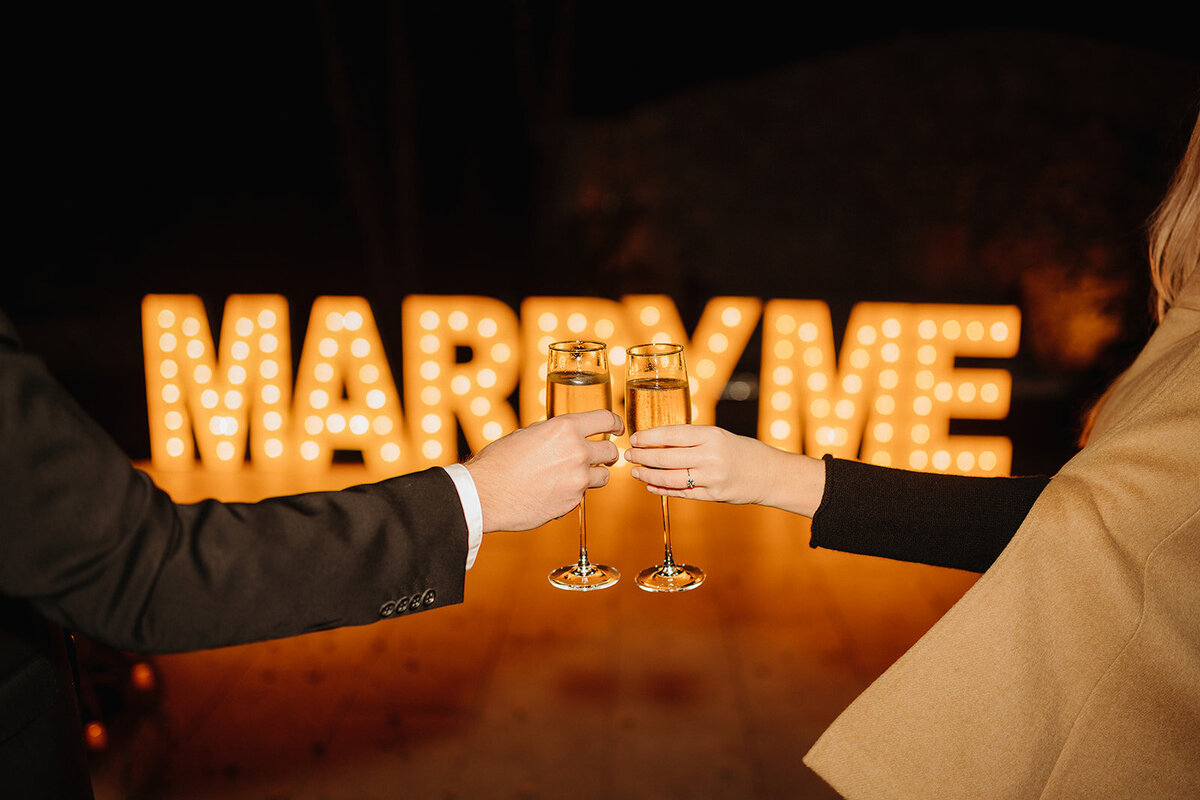 How to propose Austin couple toasting glasses of champagne