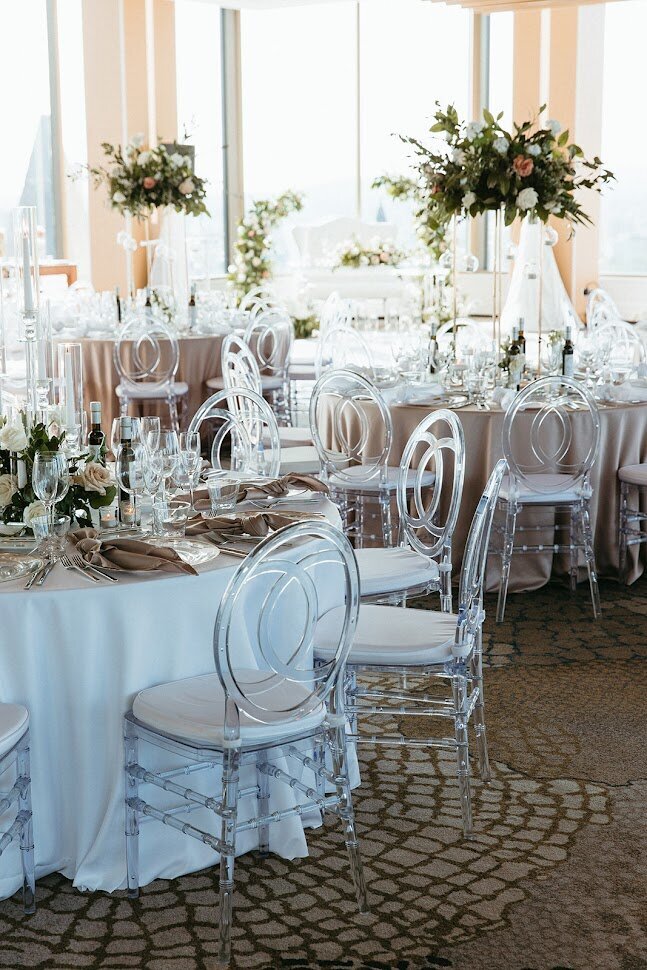This image showcases an elegant round table design in Venue TwentyTwo, featuring lush tall floral centerpieces atop taupe linens. The sophisticated arrangement highlights the beauty of modern decor, making it perfect for weddings and upscale events in Ottawa. With its stylish combination of textures and colors, this setup is sure to inspire couples seeking a chic reception look.