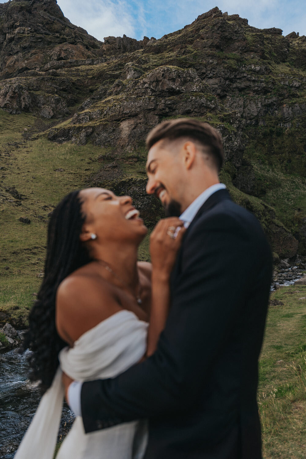 Newlyweds laugh while holding each other 