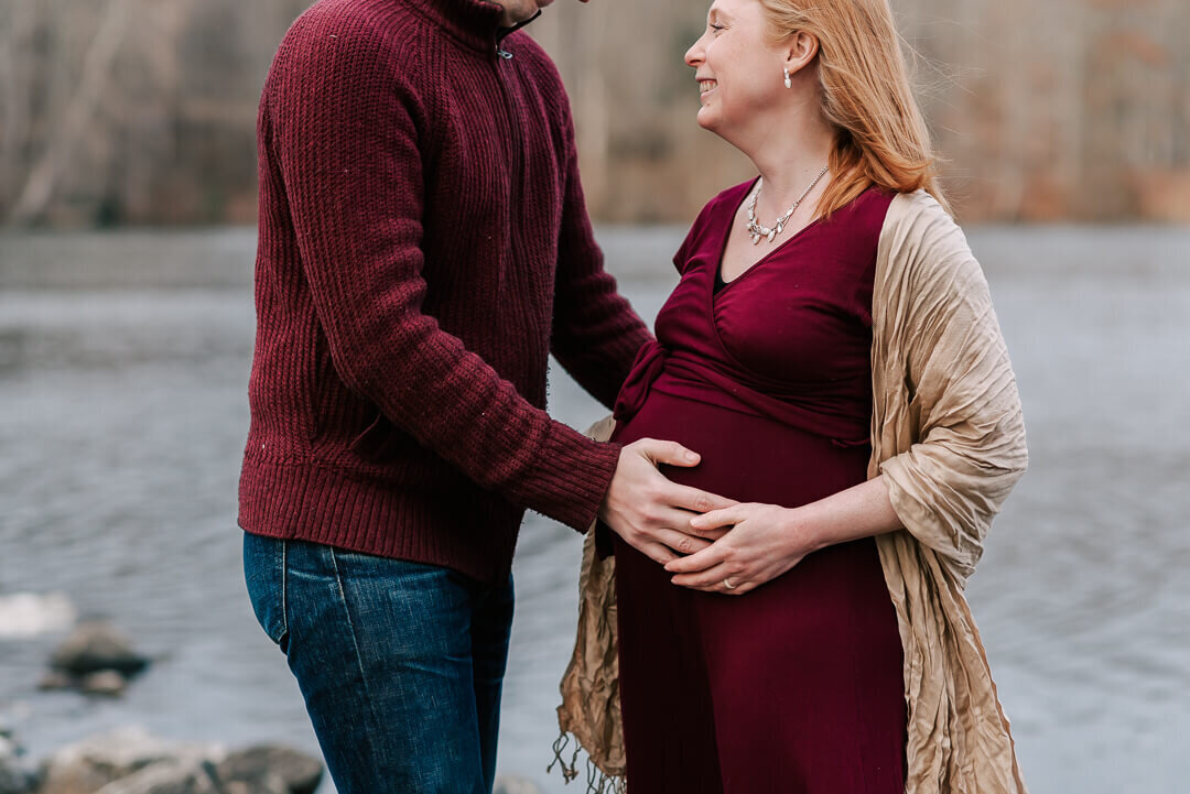 A closer shot of a woman's pregnant belly being held by her and her partner