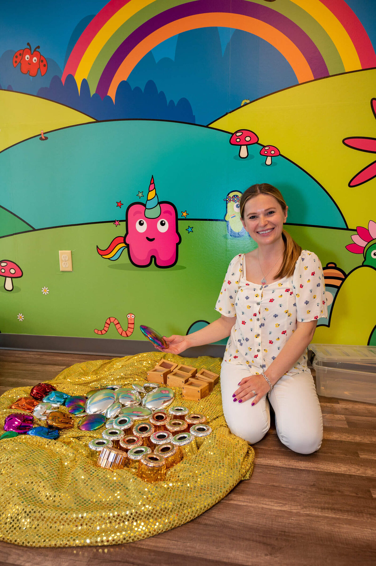 Businessowner showing off colorful sensory toys for children in her new permanent location for Hartbeeps classes.