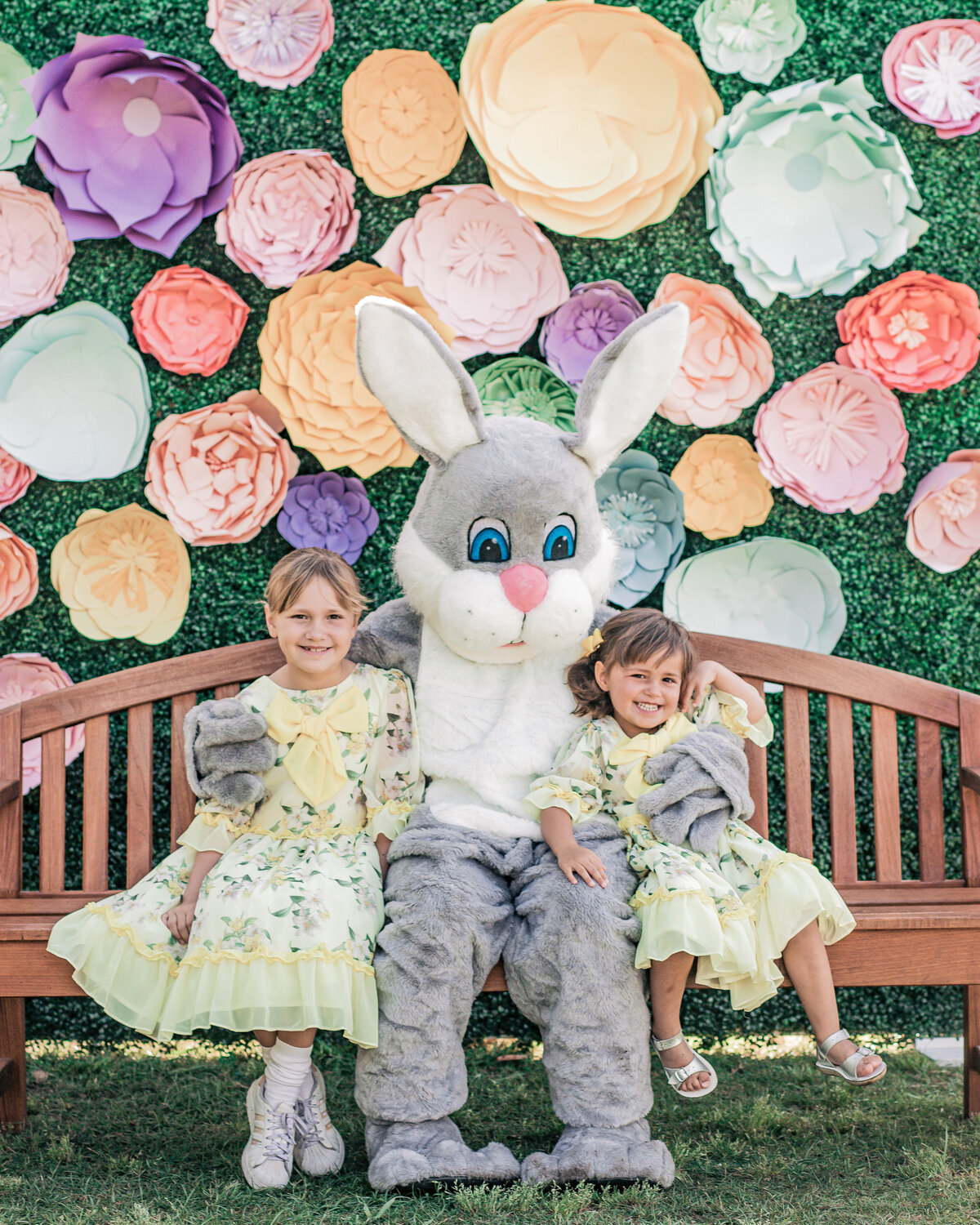 Easter bunny and kids posing in front of a paper flower Easter themed backdrop design