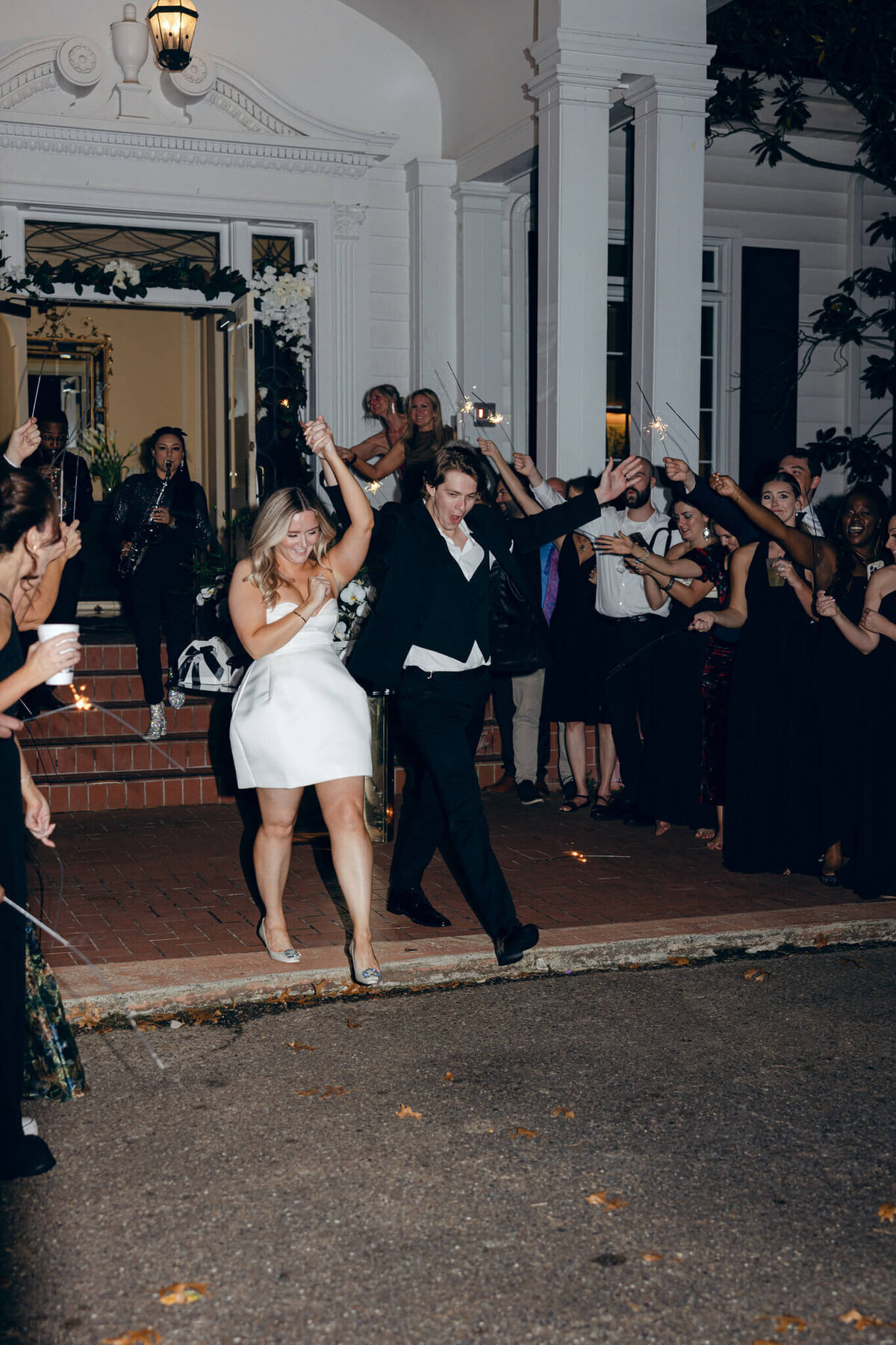 A wedding photo of the bride and groom leaving the wedding recpetion