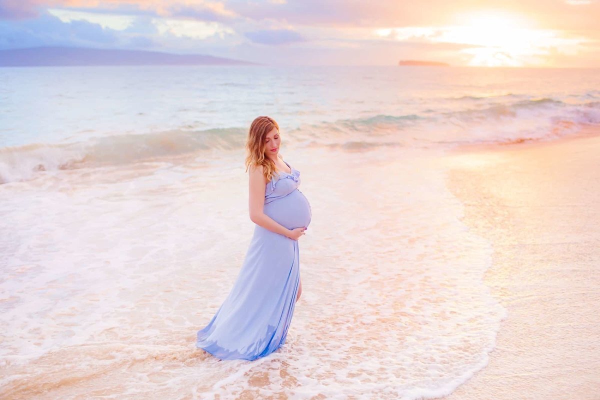 Pregnancy portraits in Wailea by Love + Water featuring a beautiful brunette woman holding her third trimester belly.