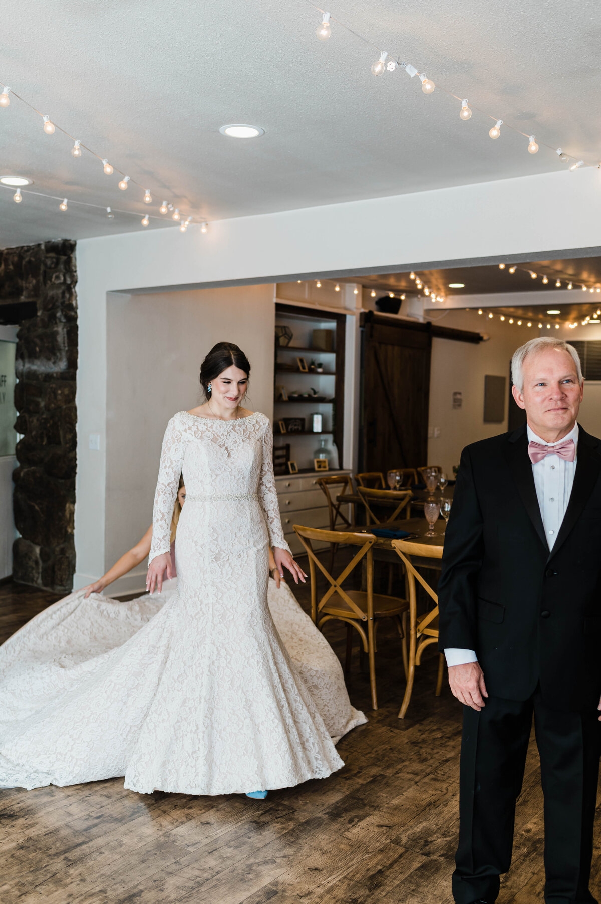 Bride walks up behind her dad for a fist look before her wedding ceremony begins at Boulder Wedgewood