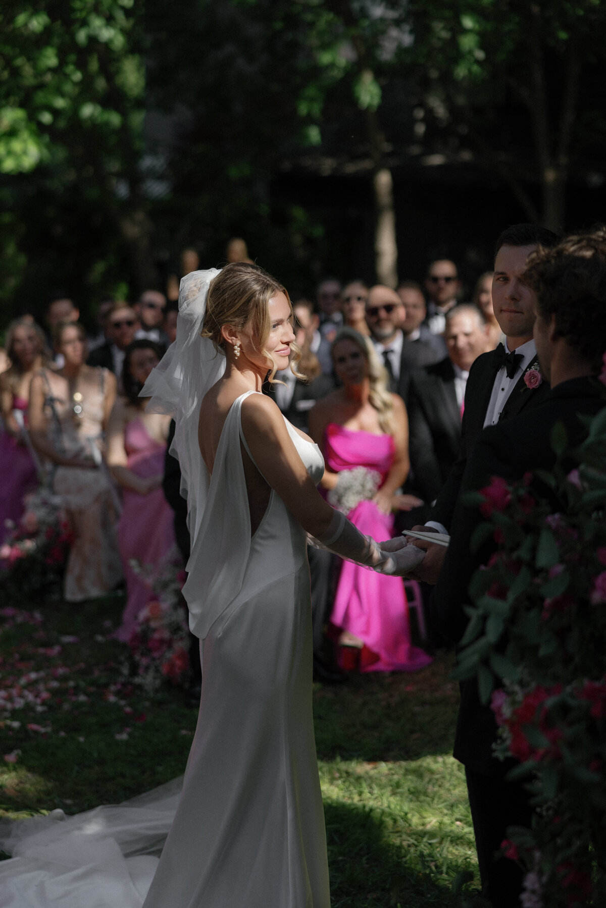 Bride standing in bright light at outdoor wedding ceremony in Austin.