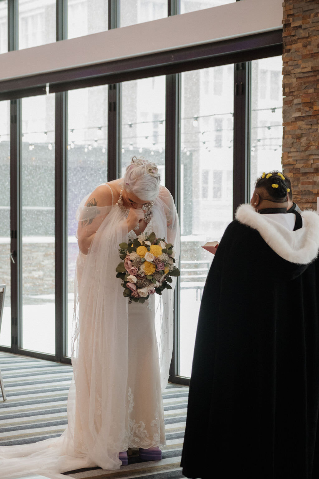 A person wiping their tears during their wedding ceremony.