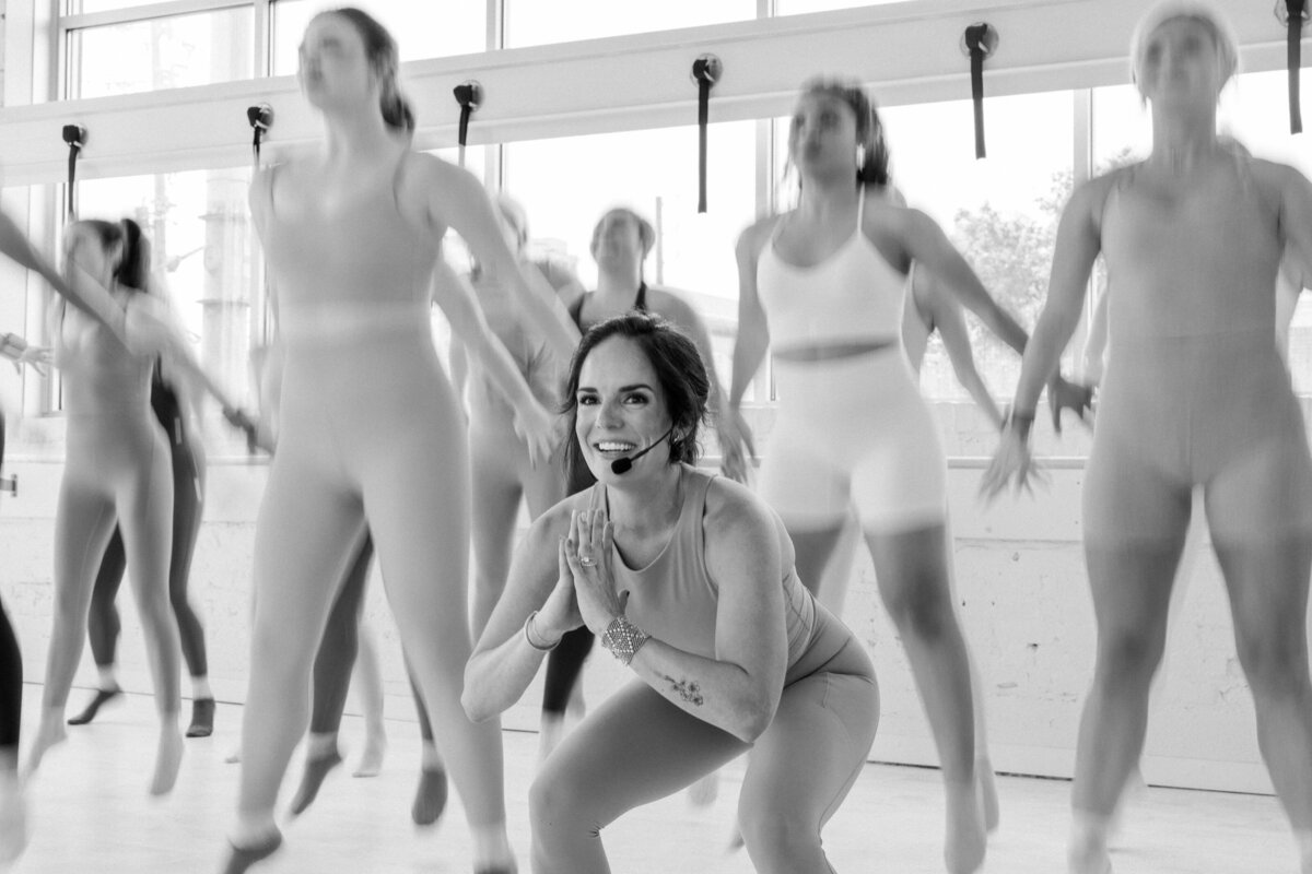 Women in a workout class doing jump squats