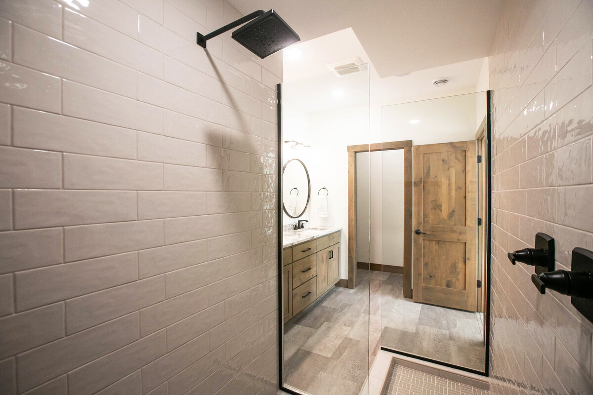 Custom bathroom with dark cabinets, double vanity, and walk-in shower in Elk River custom home