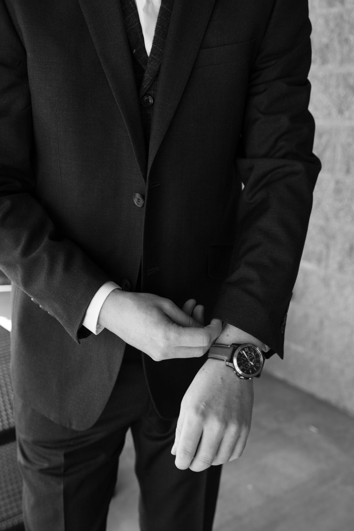 groom adjusting his watch on his wedding day