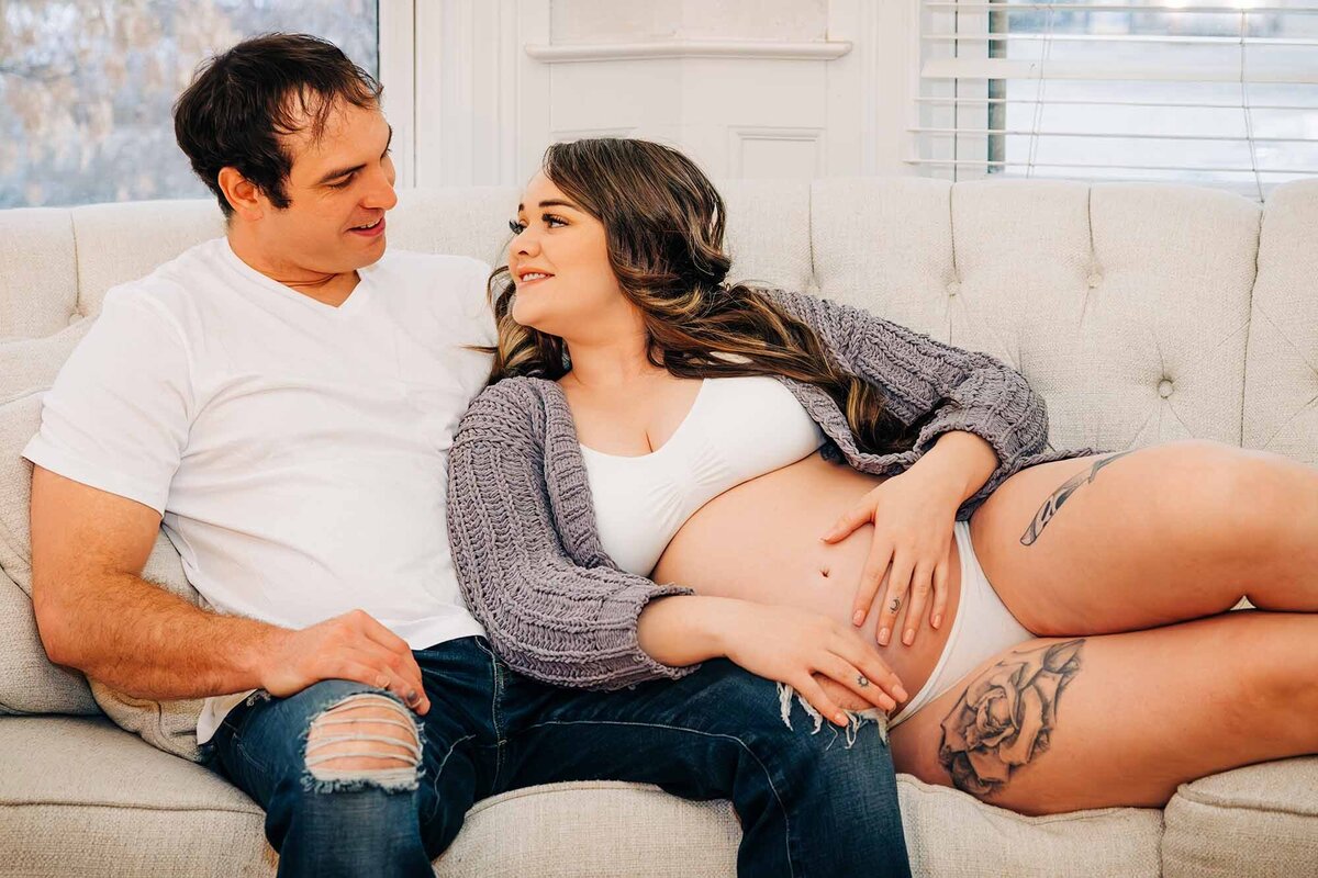 Maternity couples photo man and wife sitting on cough