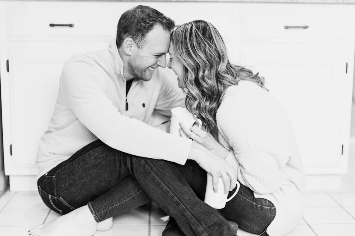 Fun, barefoot married couple snuggling in kitchen during Chicago family photography session.
