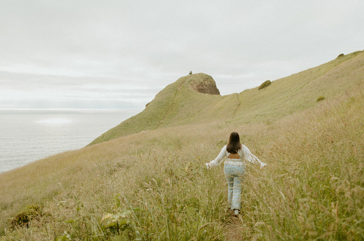 girl walking along cliffside in Oregon