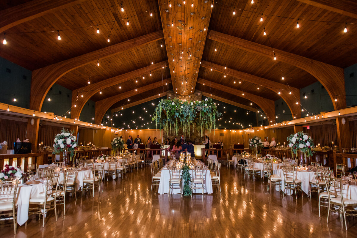 beautiful twinkle lights and greenery adorn this wedding reception at the glessner auditorium at oglebay resort in wheeling west virginia