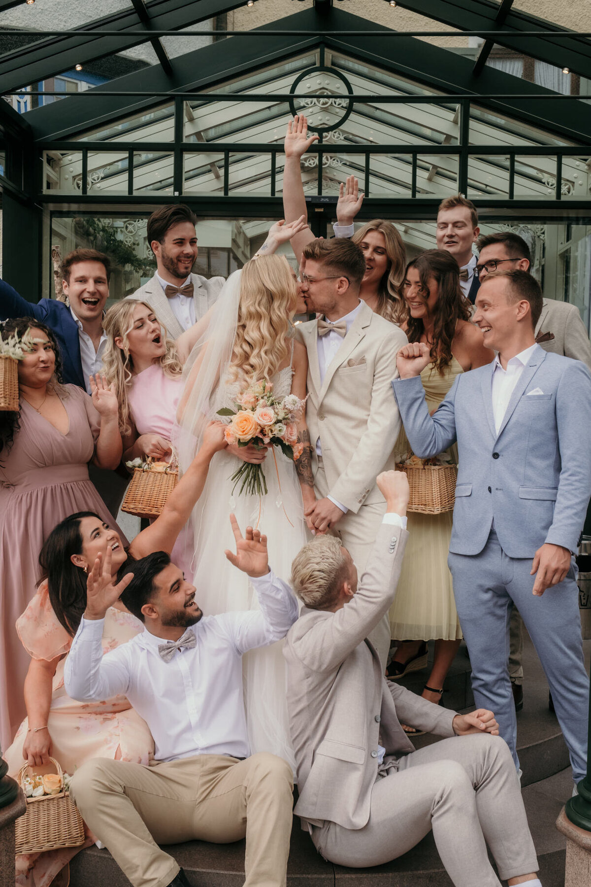 Group picture of the wedding couple with their friends outside the venue - candid wedding photography.