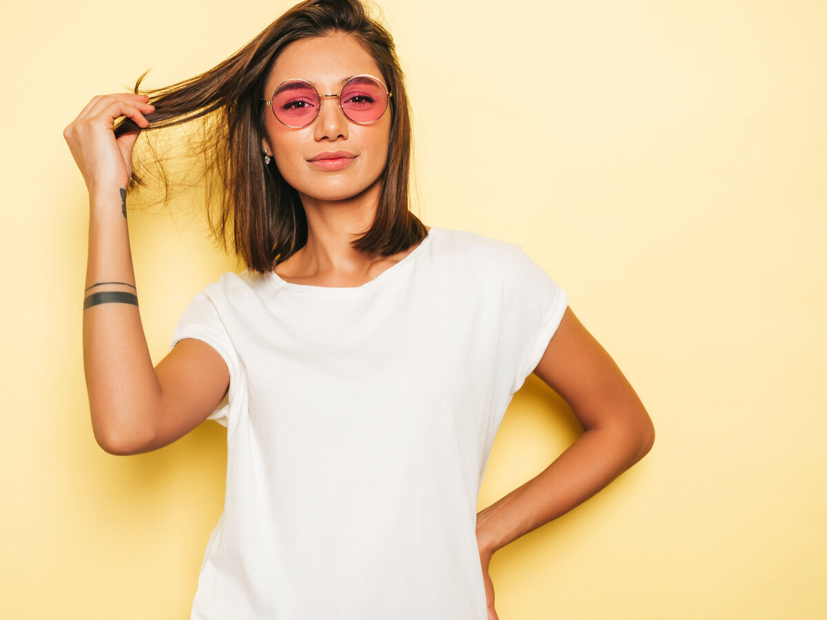 young-beautiful-woman-looking-camera-trendy-girl-casual-summer-white-t-shirt-jeans-shorts-round-sunglasses-positive-female-shows-facial-emotions-funny-model-isolated-yellow