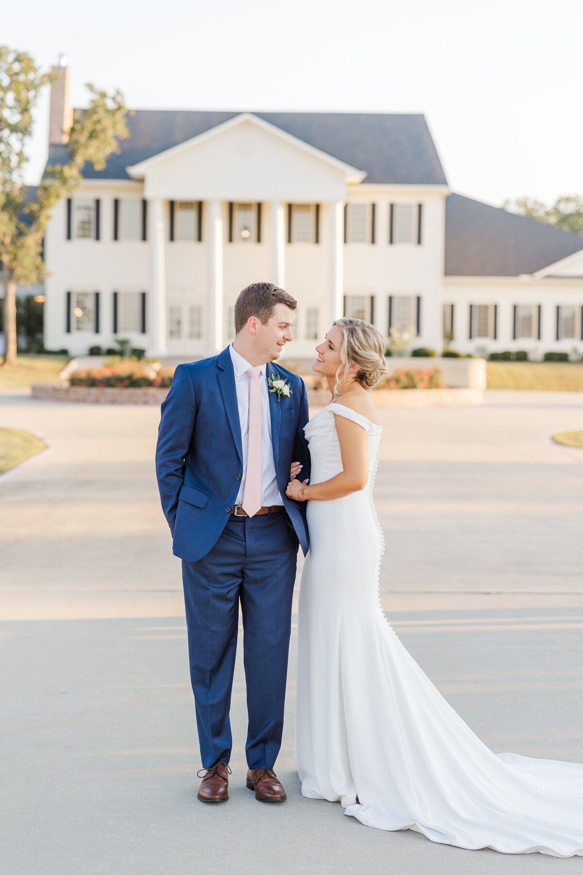 Light and airy wedding photo of a bride and groom sharing a quiet moment in front of a Southern-inspired estate near Southlake, TX. A timeless and romantic style captured with elegant natural light.