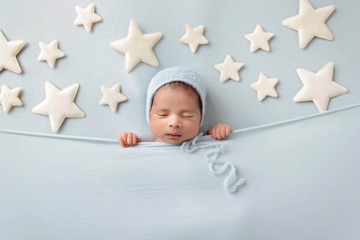 Newborn boy on a blue star-themed backdrop — Mississauga newborn photography