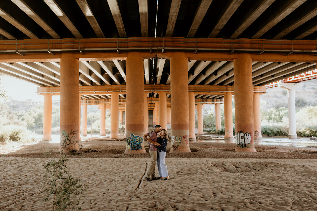 couple standing in front of a highway bridge in Albuquerque