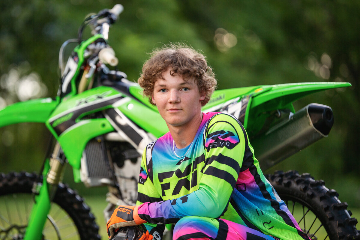Senior portrait of a boy with his motorcycle.
