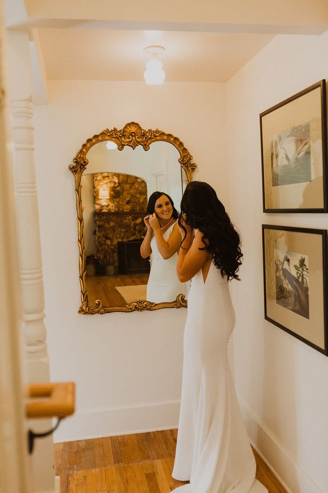 Bride putting on her earings before the ceremony on her wedding day.