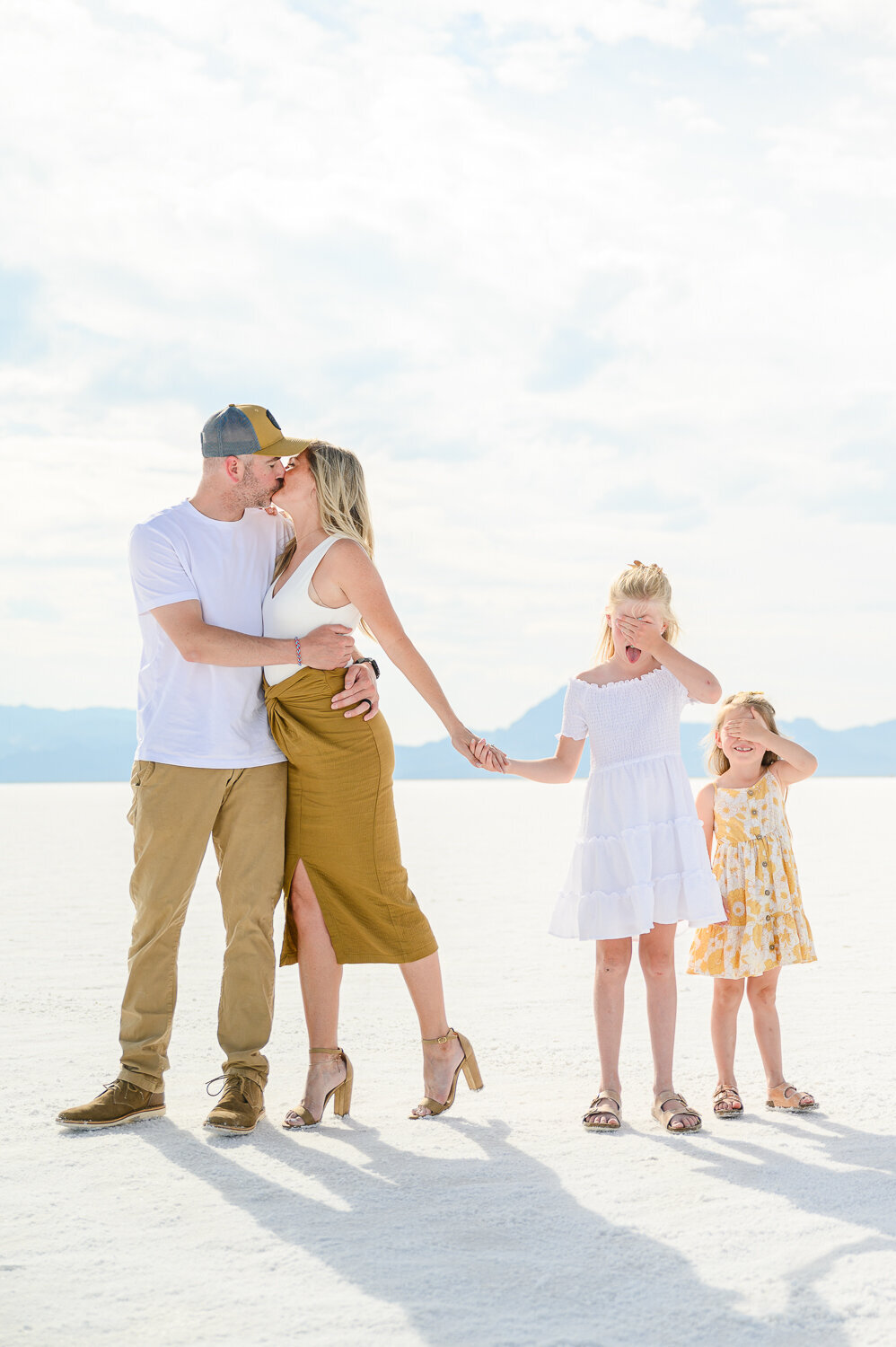family of four posing at salt flats utah for family pictures