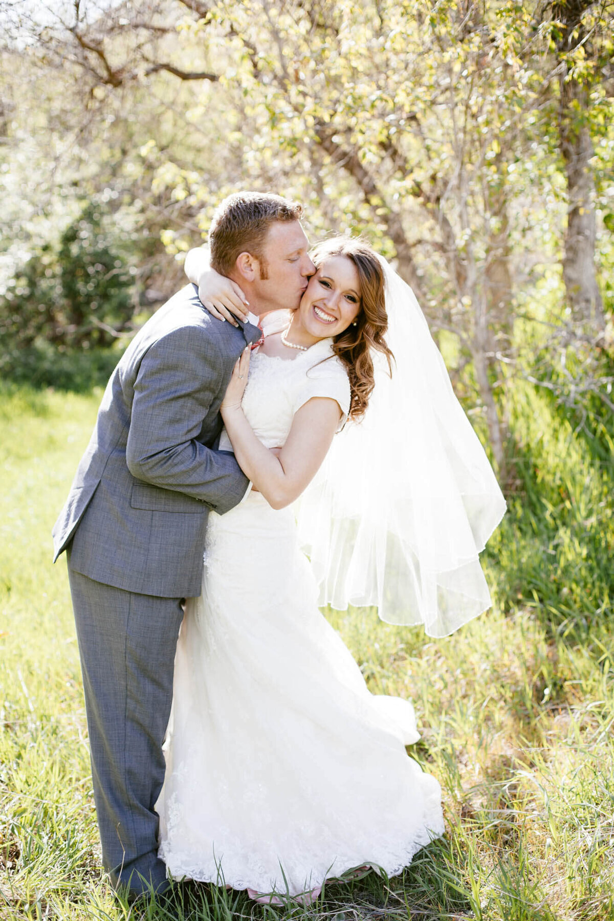 a groom kissing a bride's cheek