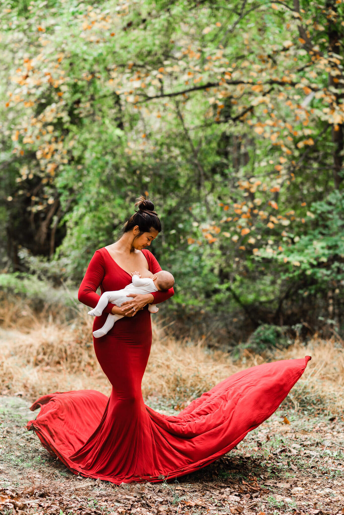 mom wearing stunning red gown breastfeeding her son, by a Northern VA newborn photographer