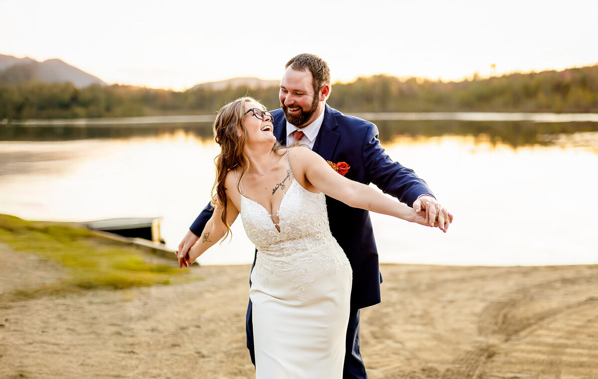 Bride and groom walking and laugh on beach