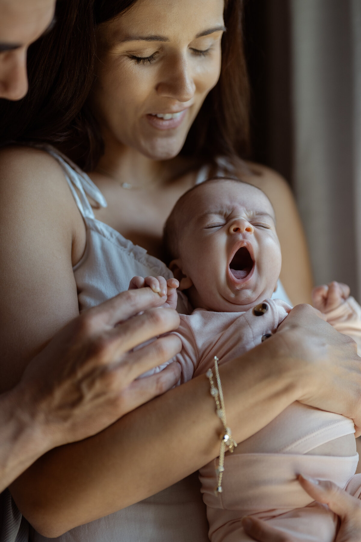 A tender close-up image of a mother smiling warmly at her baby, capturing the deep bond between them during a lifestyle session in their Fort Worth home.
