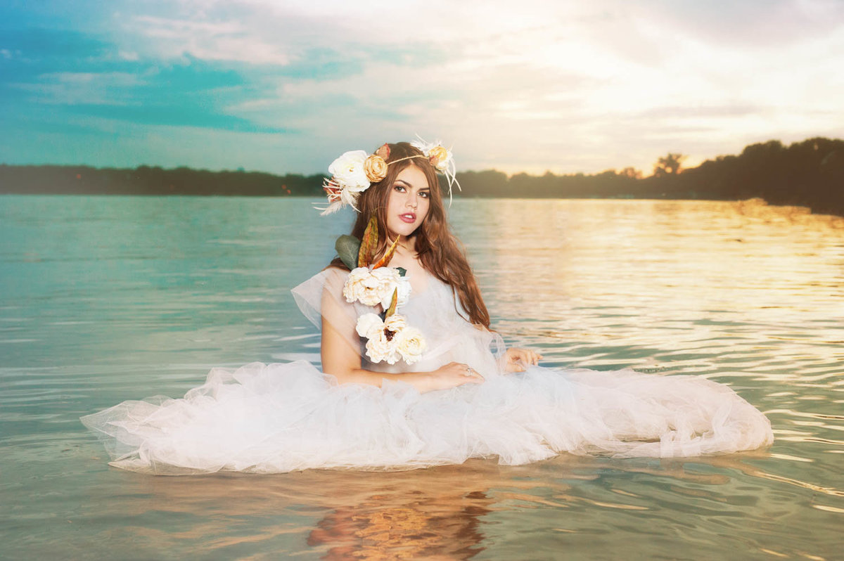 girl in white dress floating in lake